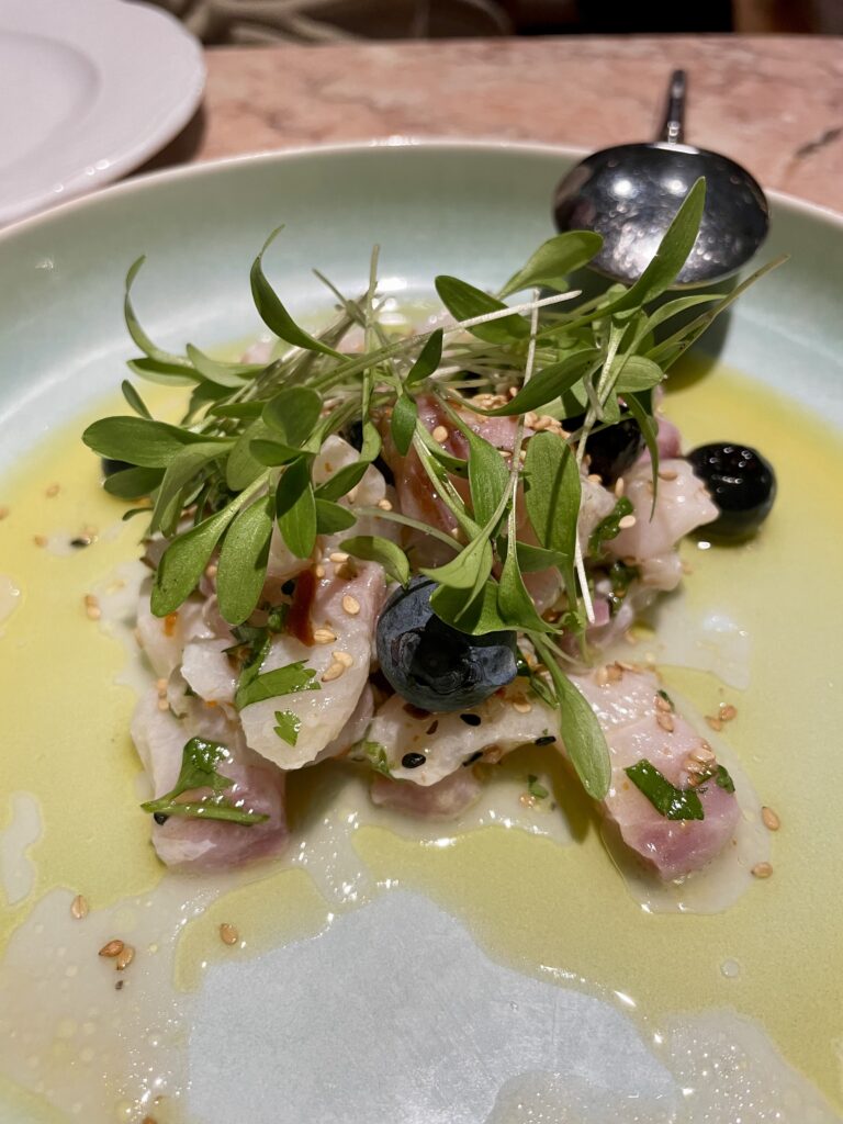 Marinated fish with lemon, dried tomato, blueberries, chilli, and coriander